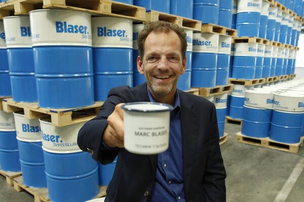 Marc Blaser von Blaser Swisslube vor Blaser-Fässer mit Kühlschmiermitteln