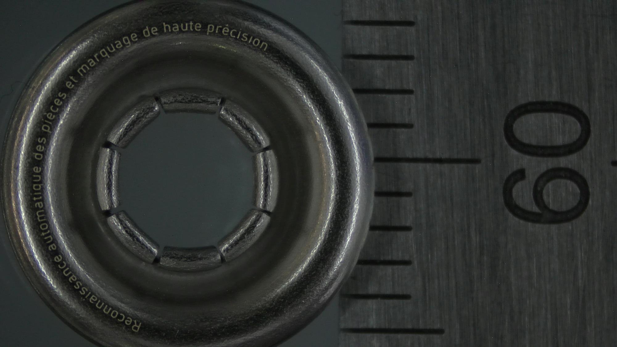 Filigrane Laserbeschriftung einer Metallöse von 11mm Durchmesser