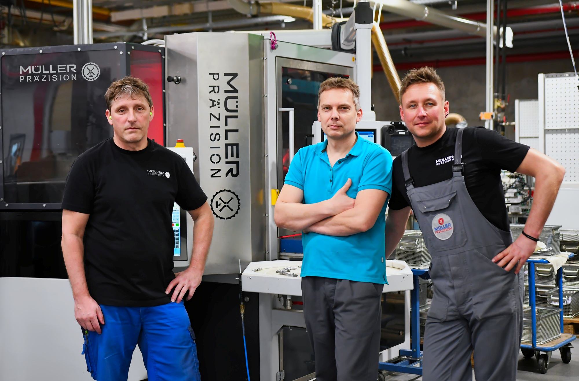 Erfolgreiche Partnerschaft: Müller Präzision Schleifexperten vor der hochautonomen Spitzenlosschleifmaschine Cube 350.