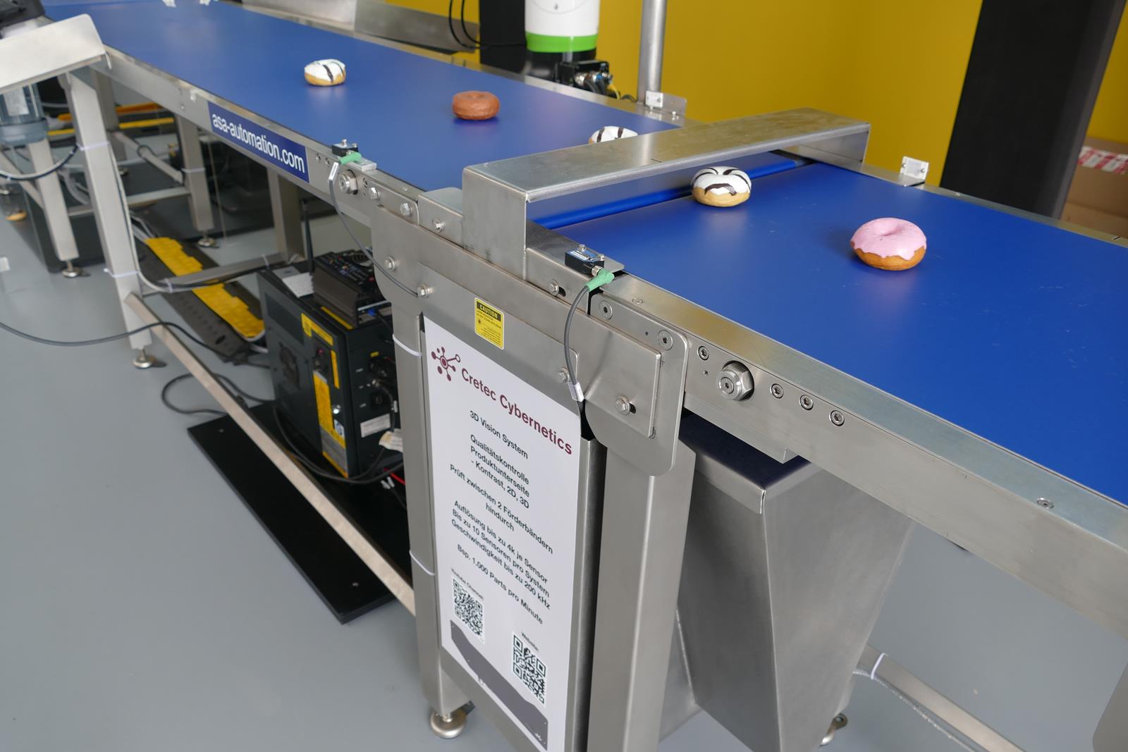 An der ersten Bildverarbeitungsstation reicht ein ganz schmaler Spalt zwischen zwei Transportbändern